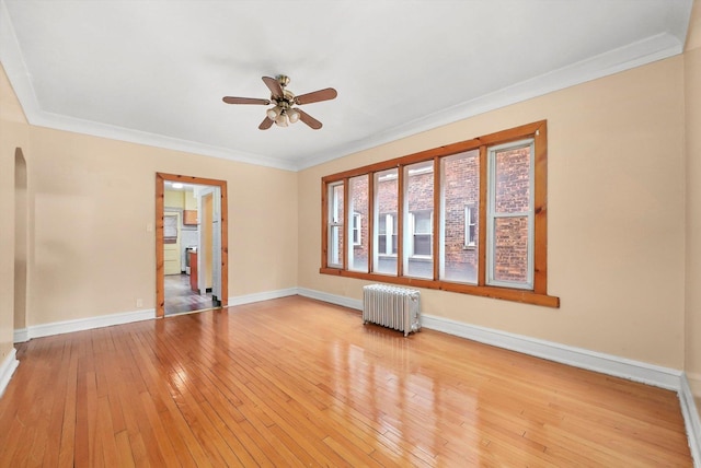 empty room with radiator, ceiling fan, light hardwood / wood-style flooring, and ornamental molding