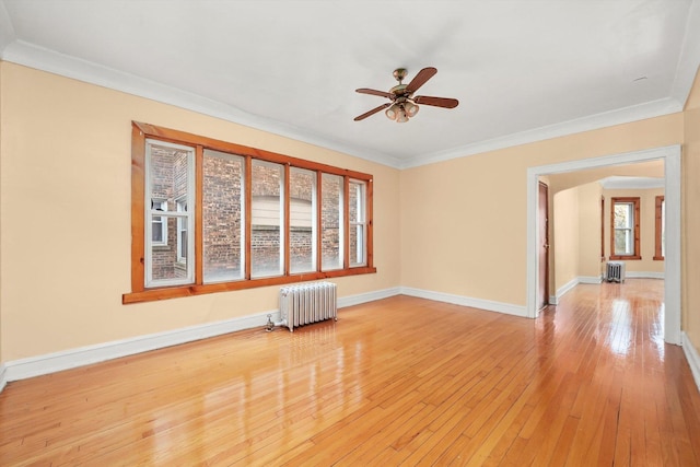 empty room with radiator heating unit, ceiling fan, and crown molding