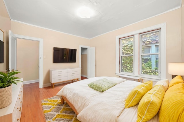 bedroom featuring crown molding and light hardwood / wood-style floors