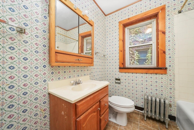 bathroom featuring radiator, vanity, crown molding, a bath, and toilet