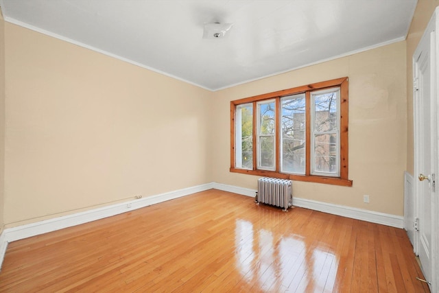 unfurnished room featuring ornamental molding, radiator, and light hardwood / wood-style flooring