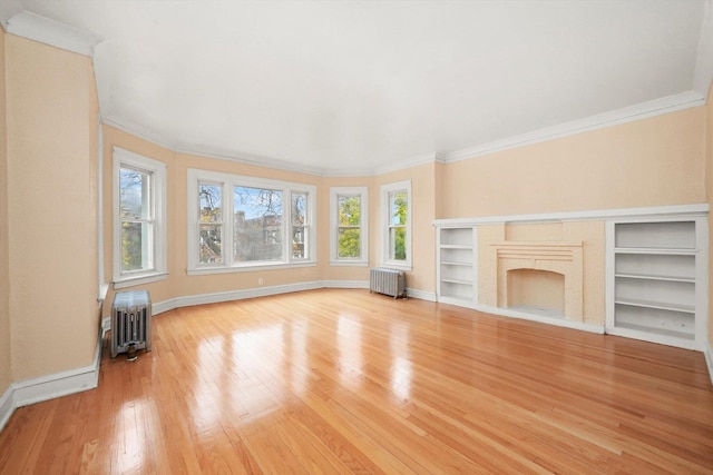 unfurnished living room with light wood-type flooring, crown molding, and radiator