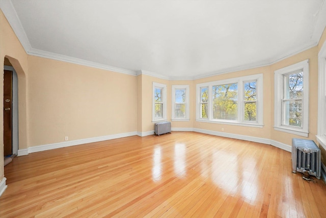 interior space with light hardwood / wood-style floors, radiator, and crown molding