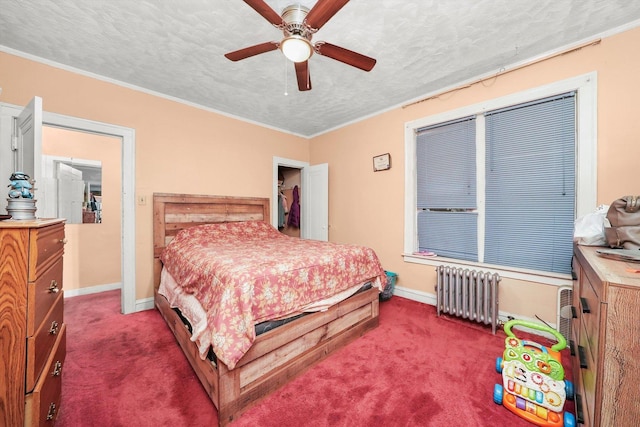 carpeted bedroom with radiator heating unit, a textured ceiling, ceiling fan, and ornamental molding