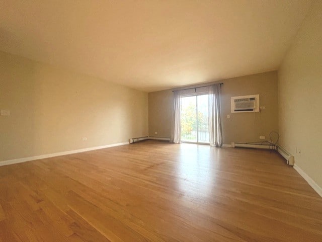 spare room with baseboard heating, light hardwood / wood-style flooring, and ceiling fan