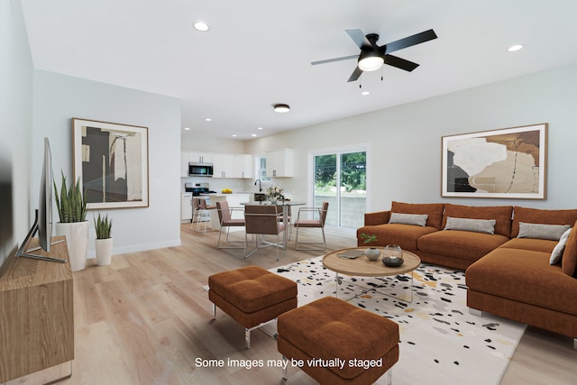 living room featuring light hardwood / wood-style floors and ceiling fan