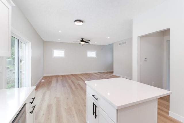 kitchen featuring ceiling fan, white cabinetry, light hardwood / wood-style flooring, and a center island