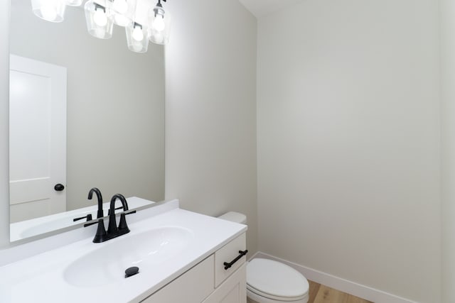 bathroom featuring toilet, vanity, and hardwood / wood-style floors