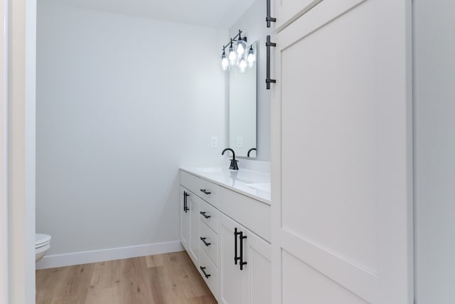 bathroom featuring toilet, vanity, and hardwood / wood-style flooring