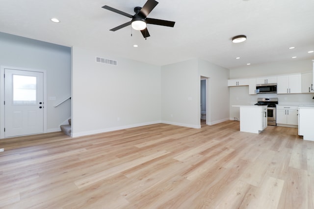 unfurnished living room featuring ceiling fan and light hardwood / wood-style floors