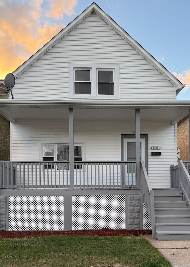 back house at dusk with a porch