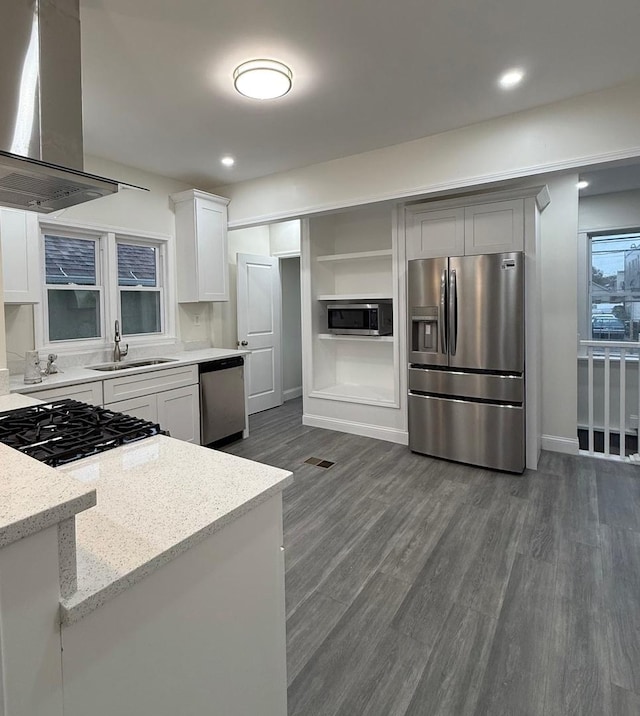 kitchen with sink, light stone counters, dark hardwood / wood-style floors, stainless steel appliances, and range hood