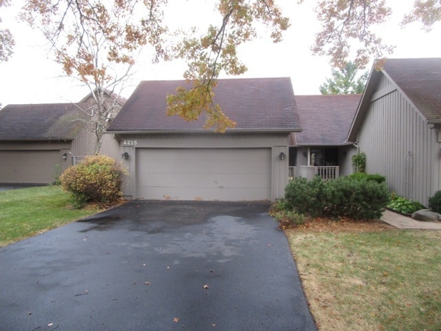 single story home featuring a garage and a front lawn