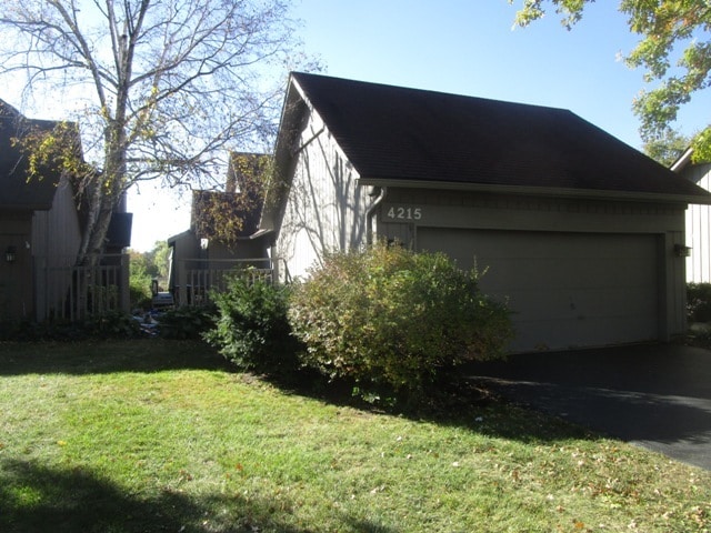 view of property exterior with a garage and a yard