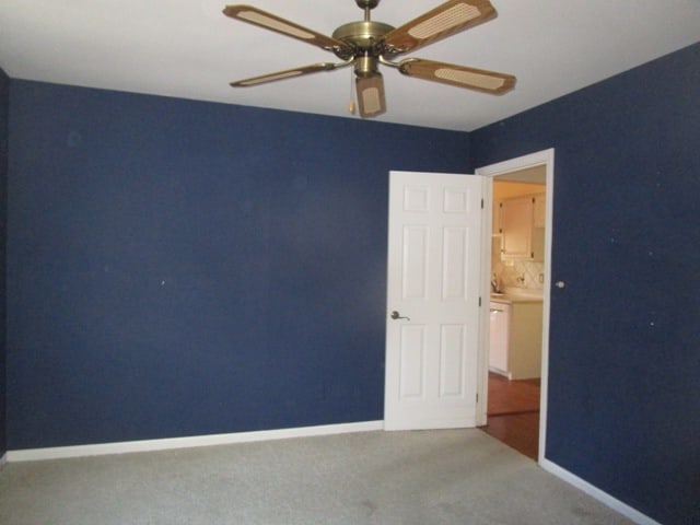 unfurnished room with ceiling fan and carpet flooring