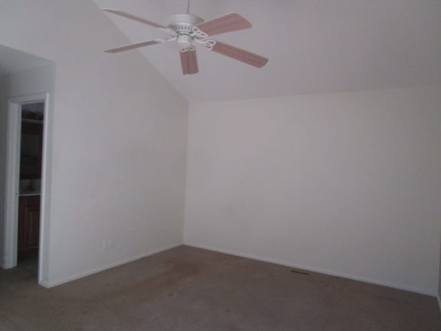 carpeted empty room featuring ceiling fan and vaulted ceiling