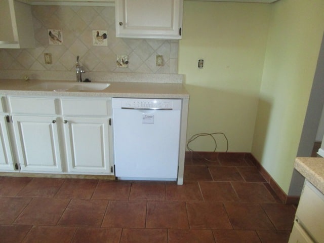 kitchen with tasteful backsplash, sink, white dishwasher, and white cabinets