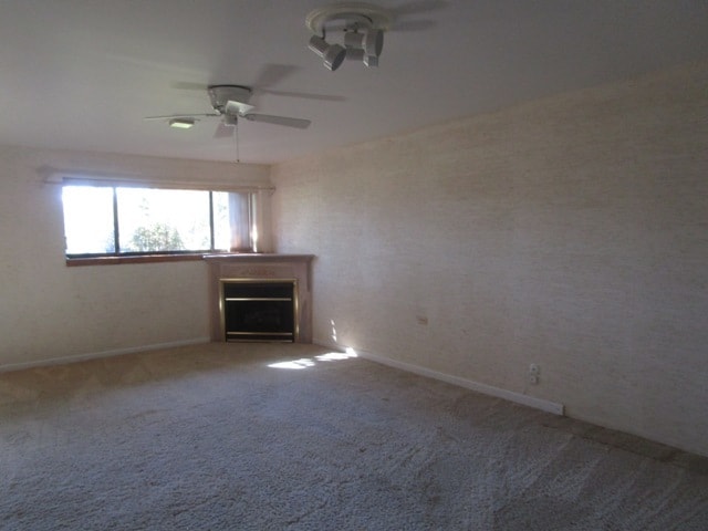 spare room featuring ceiling fan and carpet floors