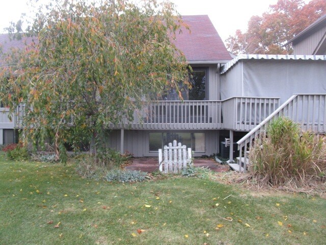 rear view of house featuring a wooden deck and a yard