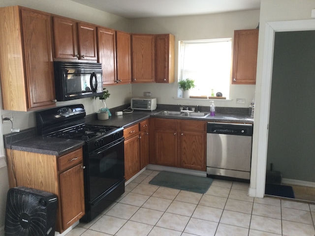 kitchen with light tile patterned floors, sink, and black appliances