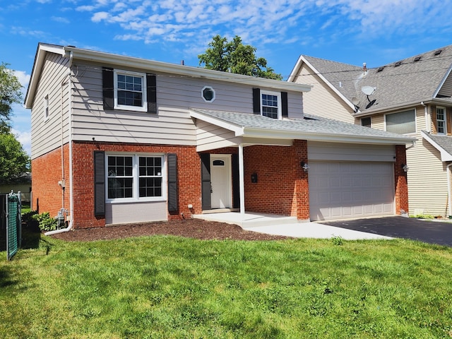 traditional home with brick siding, driveway, a garage, and a front yard