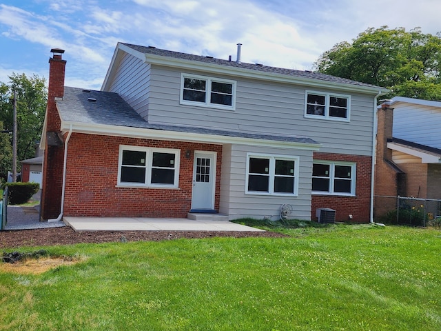 rear view of house with a chimney, brick siding, central AC unit, a patio area, and roof with shingles