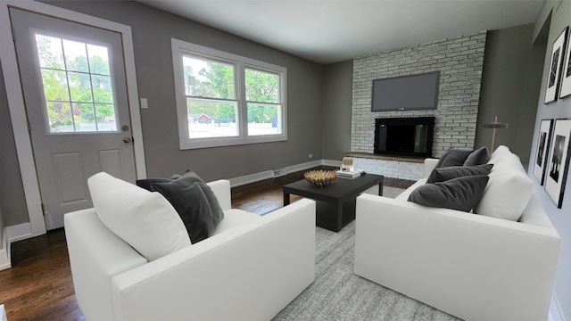 living area featuring wood finished floors, baseboards, and a brick fireplace