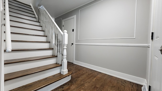 staircase with hardwood / wood-style floors and crown molding