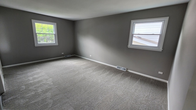 spare room featuring baseboards and carpet floors