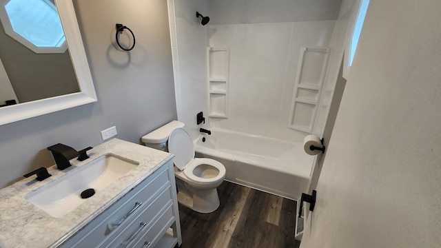 bathroom featuring wood finished floors, toilet, vanity, and washtub / shower combination