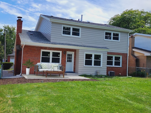 rear view of house with central air condition unit, a lawn, and a patio area