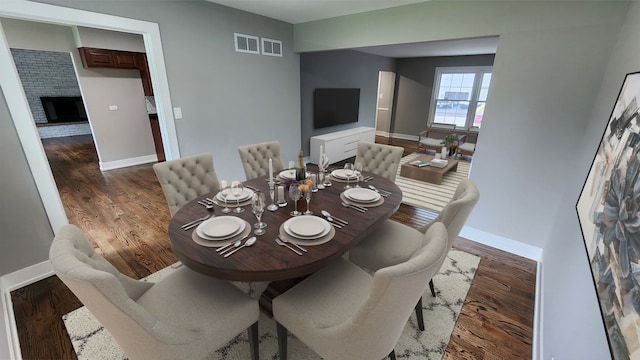 dining area featuring a brick fireplace and dark hardwood / wood-style floors