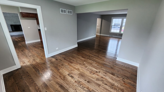 empty room featuring a fireplace and dark hardwood / wood-style floors