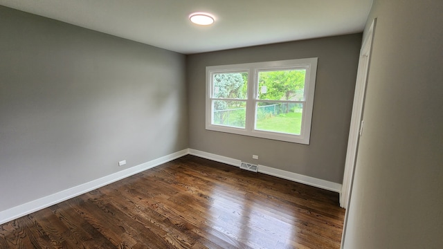 unfurnished room with dark wood-type flooring