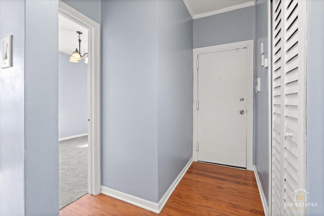 doorway with wood-type flooring and crown molding