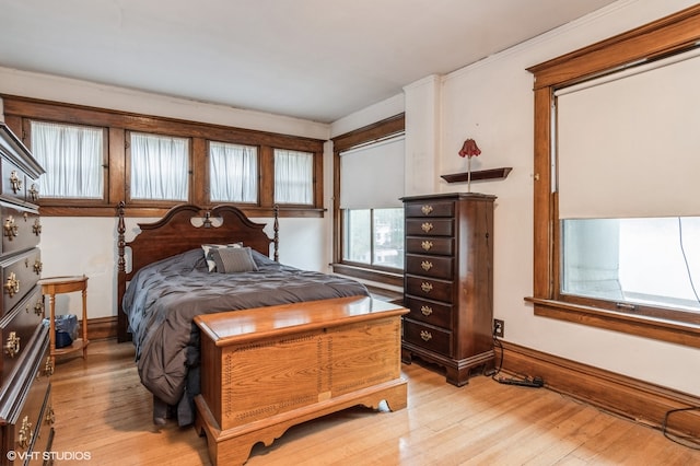 bedroom with light wood-type flooring and crown molding