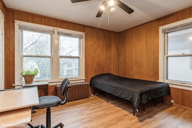 bedroom with radiator, multiple windows, ceiling fan, and light hardwood / wood-style flooring