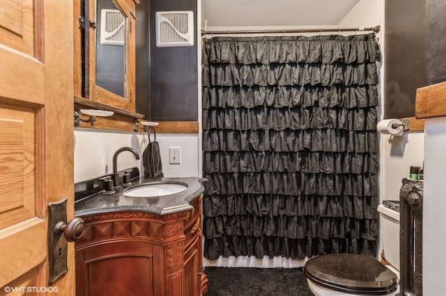 bathroom with toilet, vanity, and curtained shower