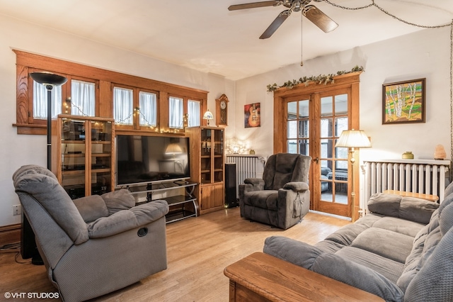 living room with light wood-type flooring, french doors, ceiling fan, and a healthy amount of sunlight