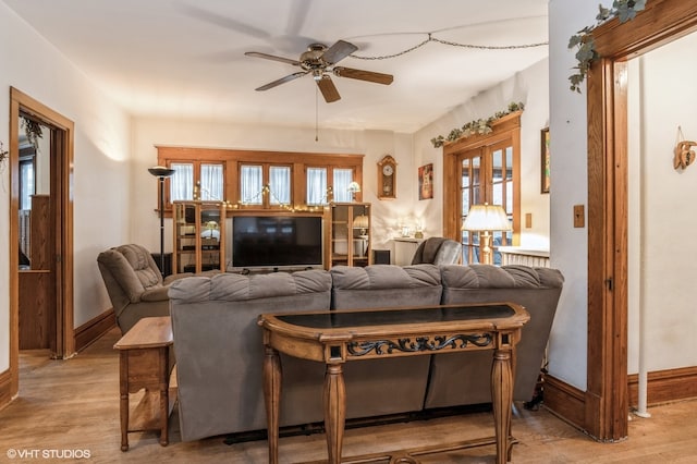 living room with ceiling fan, plenty of natural light, and light hardwood / wood-style flooring