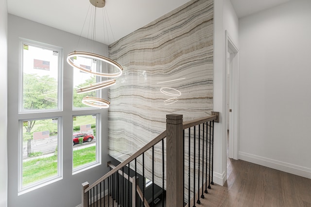 hallway with a chandelier, dark hardwood / wood-style floors, and plenty of natural light