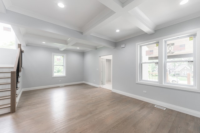 unfurnished living room with ornamental molding, beam ceiling, light wood-type flooring, and coffered ceiling