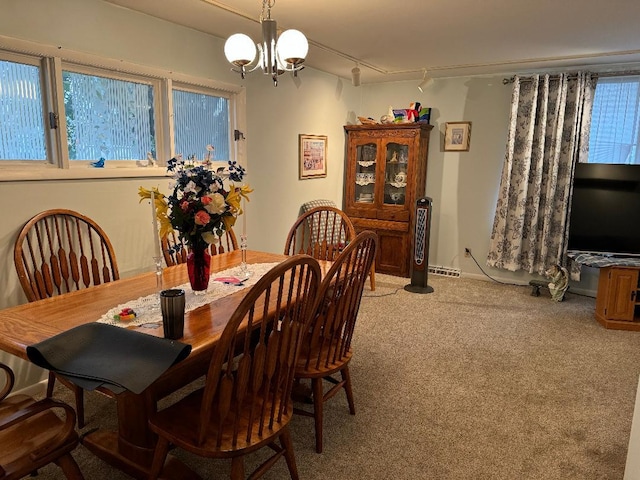 carpeted dining room featuring a wealth of natural light and a notable chandelier