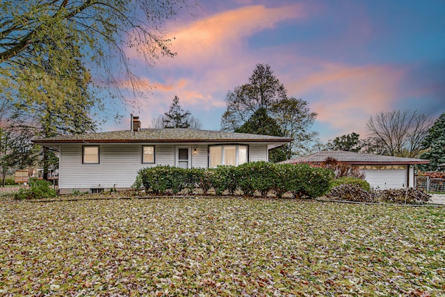 ranch-style home featuring a garage and a yard