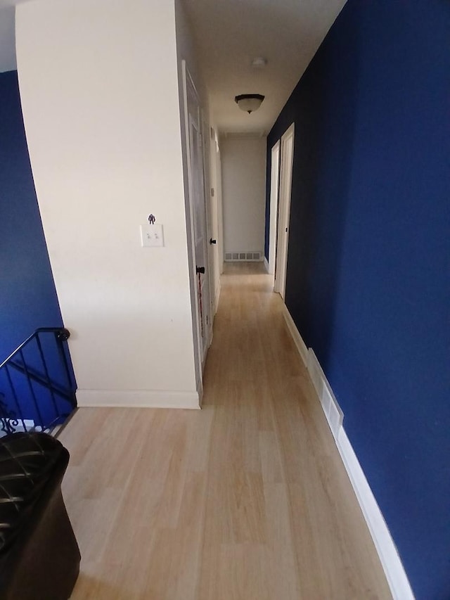 corridor featuring wood finished floors and baseboards
