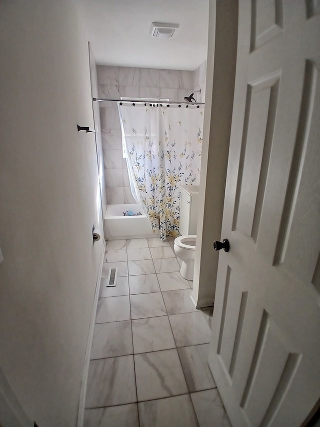 bathroom featuring shower / bath combo and toilet