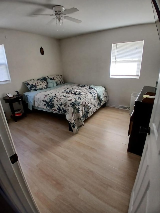 bedroom with light wood finished floors and a ceiling fan