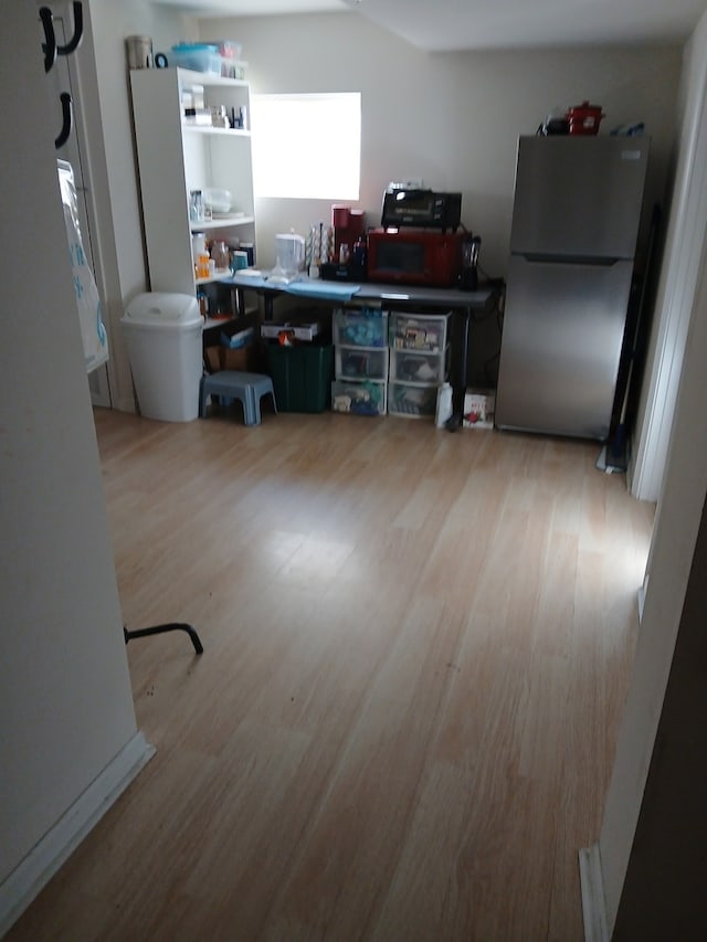 kitchen with stainless steel refrigerator and light hardwood / wood-style flooring