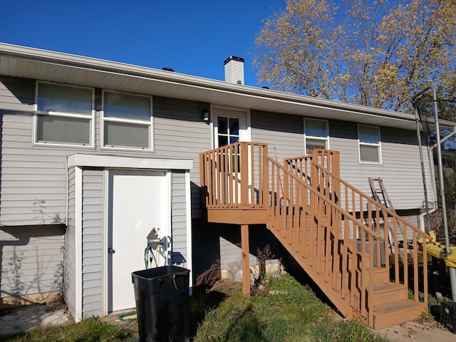 rear view of house featuring a garage and a wooden deck