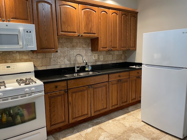 kitchen featuring tasteful backsplash, white appliances, sink, and light tile patterned floors